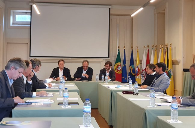 Na imagem v&ecirc;-se uma grande mesa retangular com os presidentes dos munic&iacute;pios do Alto Minho sentado ao seu redor